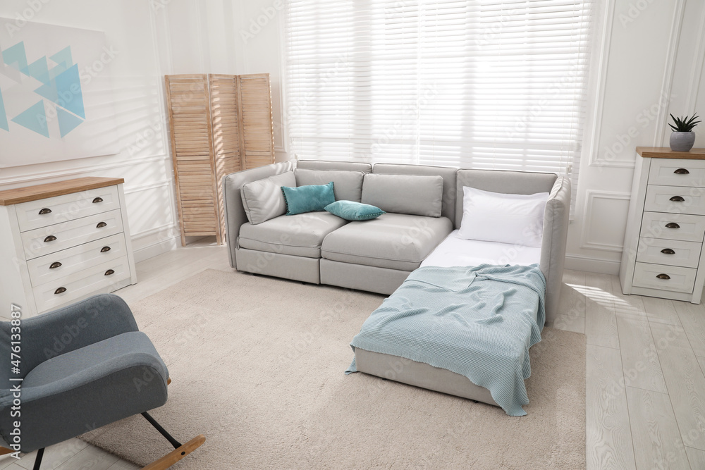 Stylish room interior with sleeper sofa and rocking chair. Additional ...