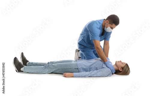 Doctor in uniform practicing first aid on woman against white background © New Africa