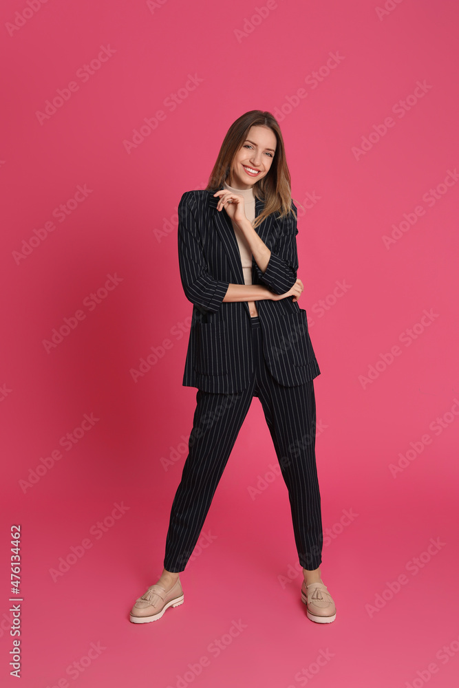 Full length portrait of beautiful young woman in fashionable suit on pink background. Business attire Full length portrait of beautiful young woman in fashionable suit on pink background. Business attire