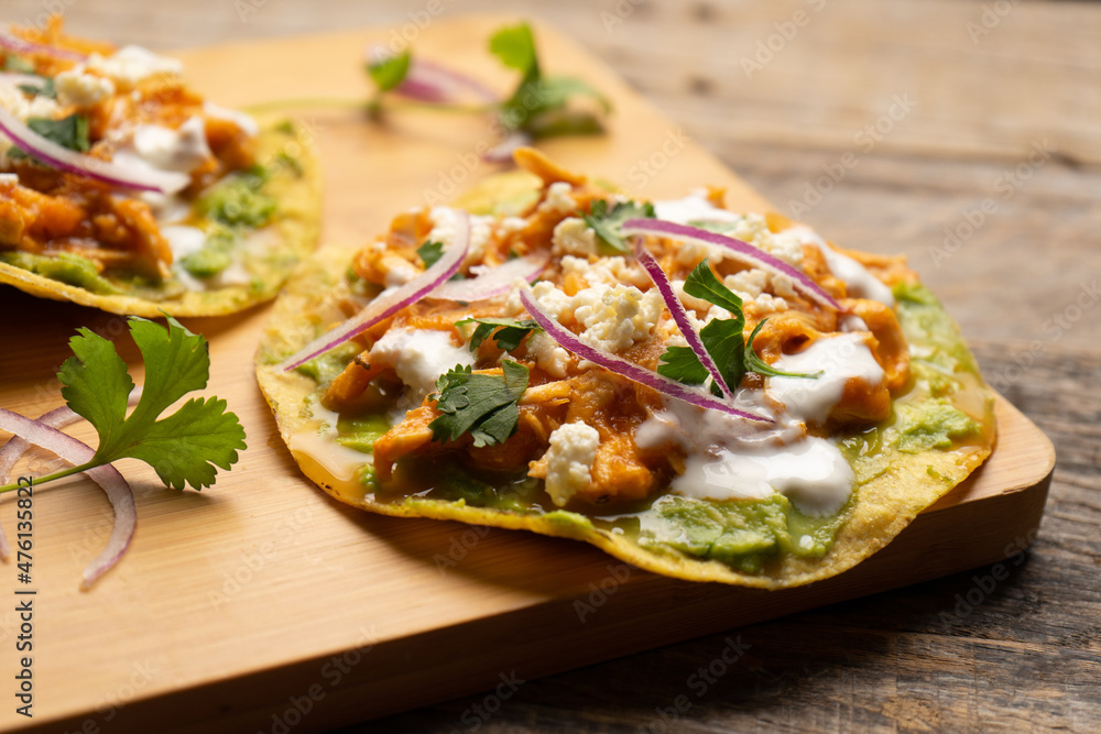 Chicken tinga tostadas with cheese and avocado. Mexican food Chicken tinga tostadas with cheese and avocado. Mexican food