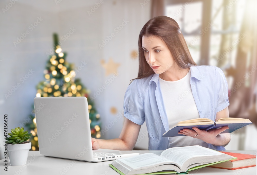Happy pretty young woman freelancer sitting at a workplace with a laptop Happy pretty young woman freelancer sitting at a workplace with a laptop