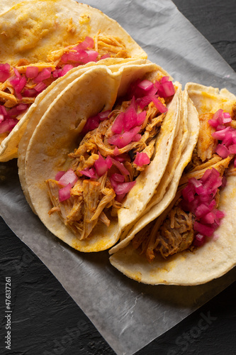 Pork meat tacos called cochinita pibil on a dark background. Mexican food photo