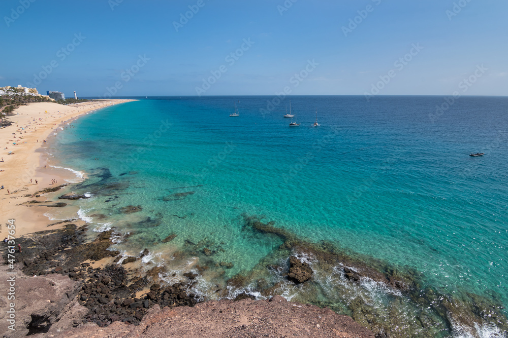 Fototapeta premium View of the beautiful and colorful Morro Jable Beach (Playa Morro Jable) from a viewpoint close by - Fuerteventura, Canary Islands, Spain