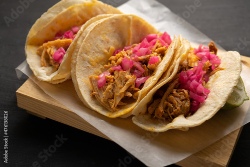 Pork meat tacos called cochinita pibil on a dark background. Mexican food