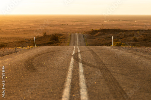 Leinwand Poster Empty asphalt highway through the dry arid nature