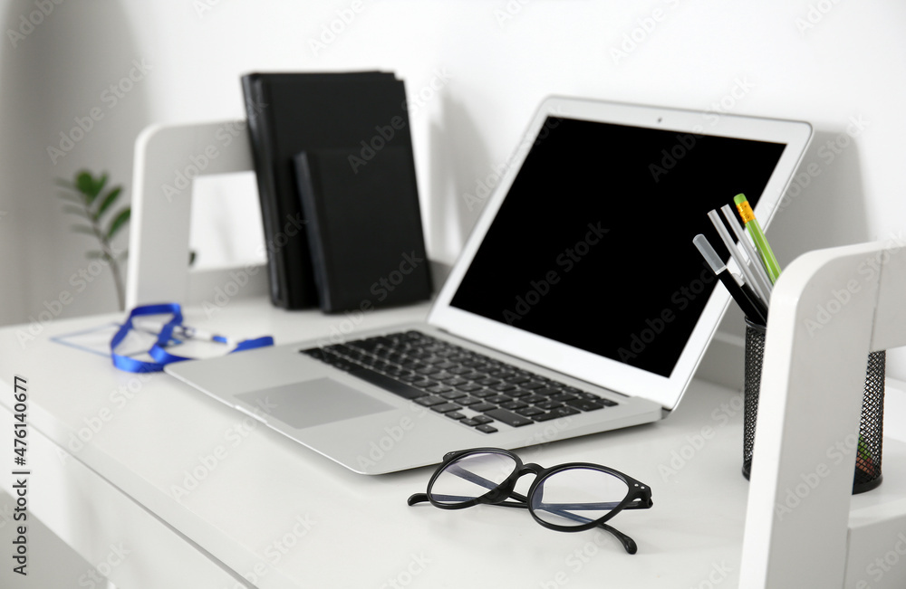 Doctor's workplace with laptop and eyeglasses in medical office Doctor's workplace with laptop and eyeglasses in medical office