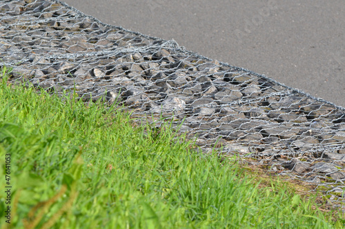 Gabion wall with gabion baskets and gabion stones in the park in autumn, retaining wall.