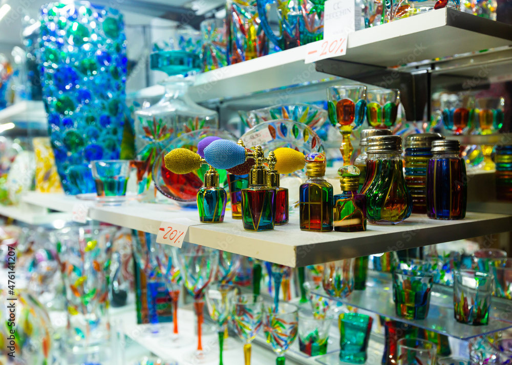 Naklejka premium Original Murano art glass figures and glassware on display in Venetian souvenir shop ..
