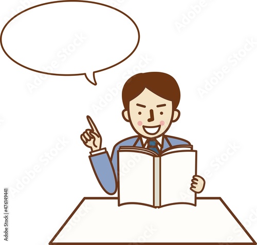 本を読みながら指を差すスーツ姿の男性。