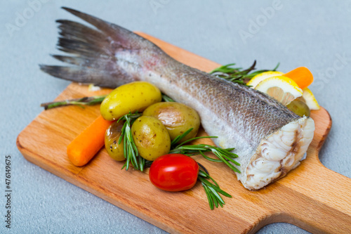 Baked hake tail with vegetables recipe - 250g hake or other cod-like fish tail rub with salt and pepper, bake in oven at220C for 20 min. Serve with potatoes and fresh vegetables photo