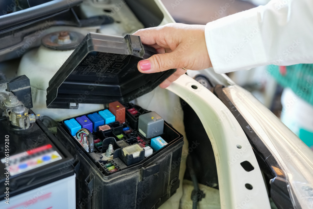 Vehicle safety concept, Woman's hand checking car engine before driving. Car Maintenance auto electric fuse box checking. Vehicle safety concept, Woman's hand checking car engine before driving. Car Maintenance auto electric fuse box checking.