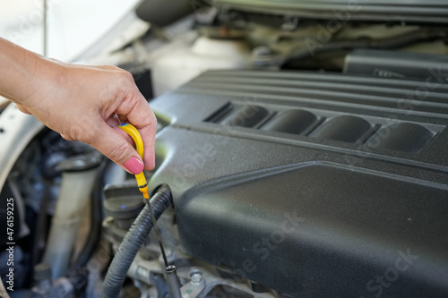 Vehicle safety concept, Woman's hand checking car engine before driving. Car Maintenance engine oil level checking.