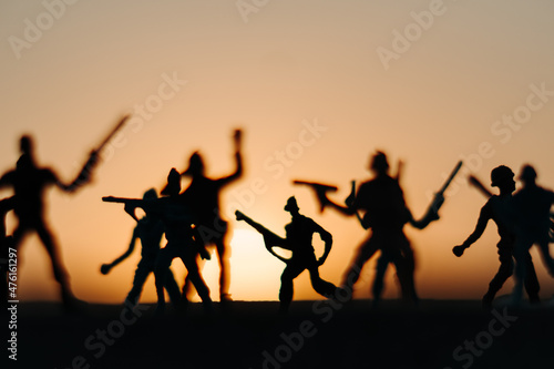 Silhouette of toy soldiers in front of the sun during the sunset. Soldiers background. War background. Soldiers in war concept © Shiv Mer
