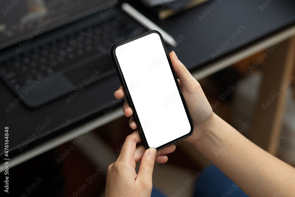 A female relaxed on her smartphone at her desk. A female relaxed on her smartphone at her desk.