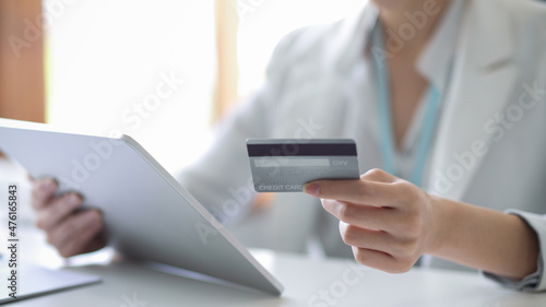 Business woman holding a digital tablet and a credit card