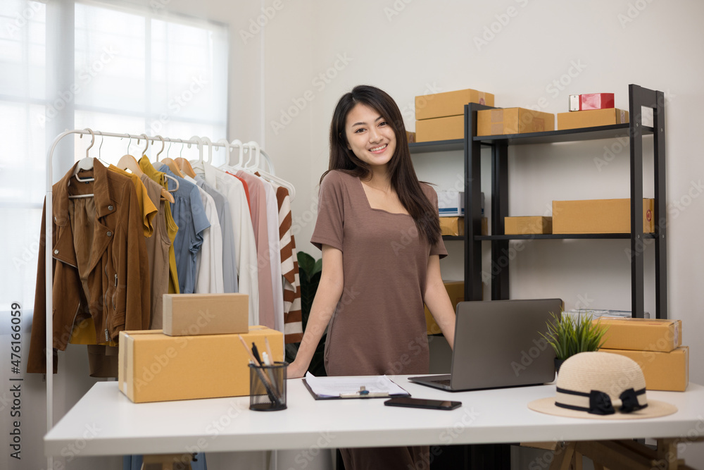 Young beautiful asian woman business owner at fashion store check stock on rails clothing standing and smile to camera. Asian female entrepreneur working in clothes shop. Young beautiful asian woman business owner at fashion store check stock on rails clothing standing and smile to camera. Asian female entrepreneur working in clothes shop.