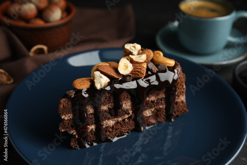 Piece of tasty homemade chocolate cake with nuts on plate  closeup