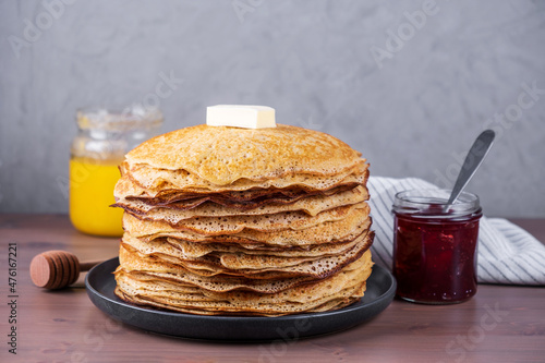 Stack of freshly baked pancakes with honey and jam. Russian traditional food. Shrovetide, folk festival with delicious food. Selective focus, copy space.
