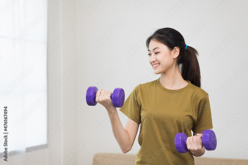Attractive asian young fitness woman lifting dumbbell weights workout at home in living room. Fresh feeling female training and exercise wearing sport wear fit body. Attractive asian young fitness woman lifting dumbbell weights workout at home in living room. Fresh feeling female training and exercise wearing sport wear fit body.