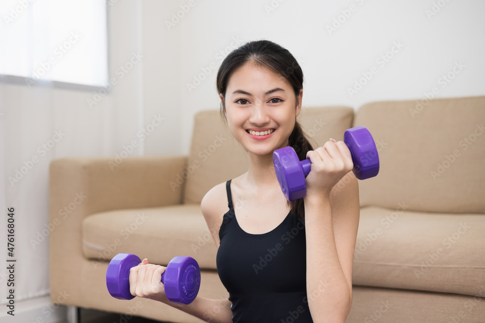Attractive asian young fitness woman lifting dumbbell weights workout at home in living room. Fresh feeling female training and exercise wearing sport wear fit body. Attractive asian young fitness woman lifting dumbbell weights workout at home in living room. Fresh feeling female training and exercise wearing sport wear fit body.