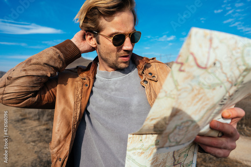 A man getting lost try to find the way in the map