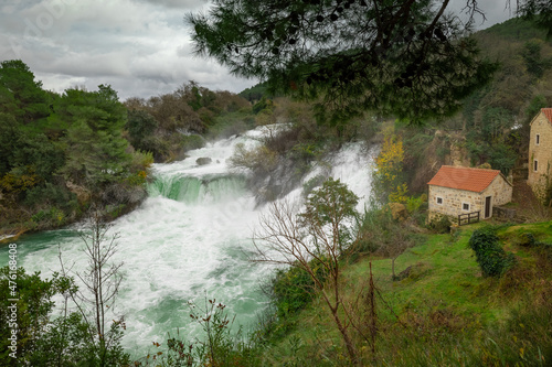Wide panorama of Beautiful Krka waterfalls at Skradinski buk viewed from the viewpoint in cold winter setting. No people visible around.