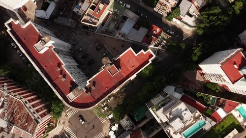 The camera is slowly declining on the rooftop in Buenos Aires. The shot covers a wide view of the district: block buildings with swimming pools on the rooftops,road intersections, smaller houses. photo