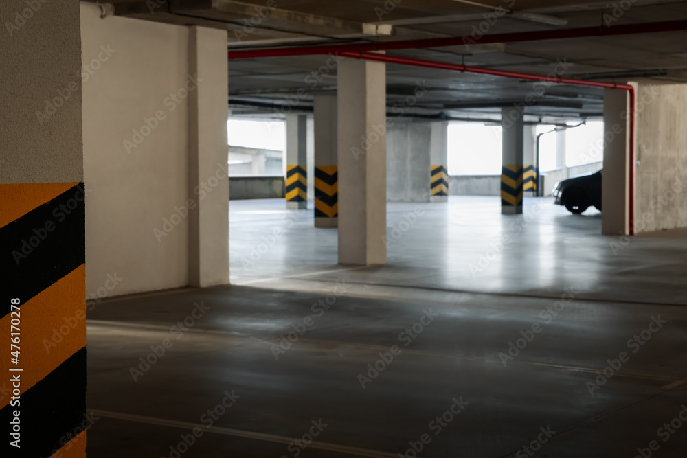 Open car parking garage, focus on column with warning stripes