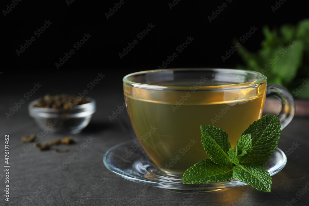 Cup of hot aromatic mint tea on grey table Cup of hot aromatic mint tea on grey table