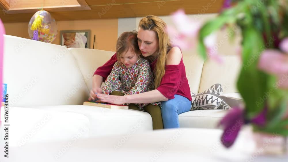 A mother holds her daughter teaching her how to do a learning puzzle. Play and Learn. A mother holds her daughter teaching her how to do a learning puzzle. Play and Learn.