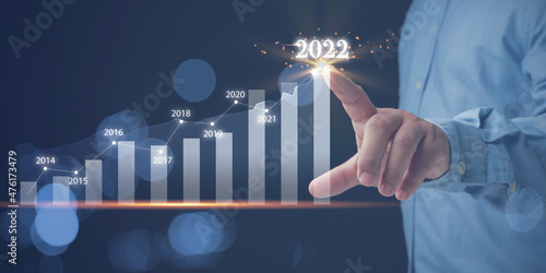 Businessman touching screen at graph year 2022. Analysis share for marketing growth business. Analysts trading share strategy analyzing from diagram graph for investment to the future.
