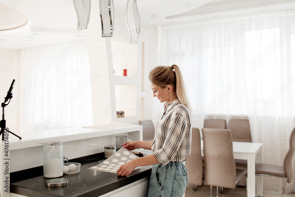 Beautiful hostess, culinary blogger shoots videos in the kitchen like an oven cookie, macarons Beautiful hostess, culinary blogger shoots videos in the kitchen like an oven cookie, macarons
