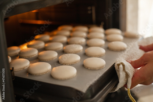 close-up of woman makes macaroons and puts it in the oven baked