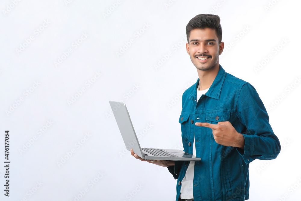 Young indian man using laptop on white background. Young indian man using laptop on white background.