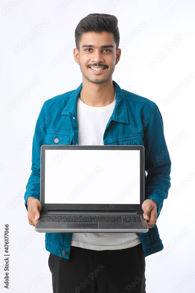 Young indian man showing laptop screen on white background. Young indian man showing laptop screen on white background.