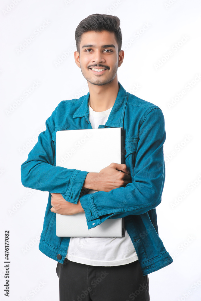 young indian man holding laptop in hand on white background. young indian man holding laptop in hand on white background.