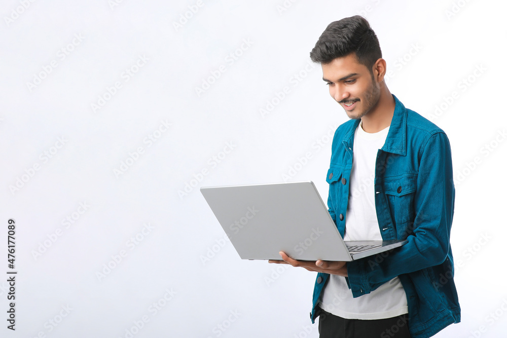 Young indian man using laptop on white background. Young indian man using laptop on white background.
