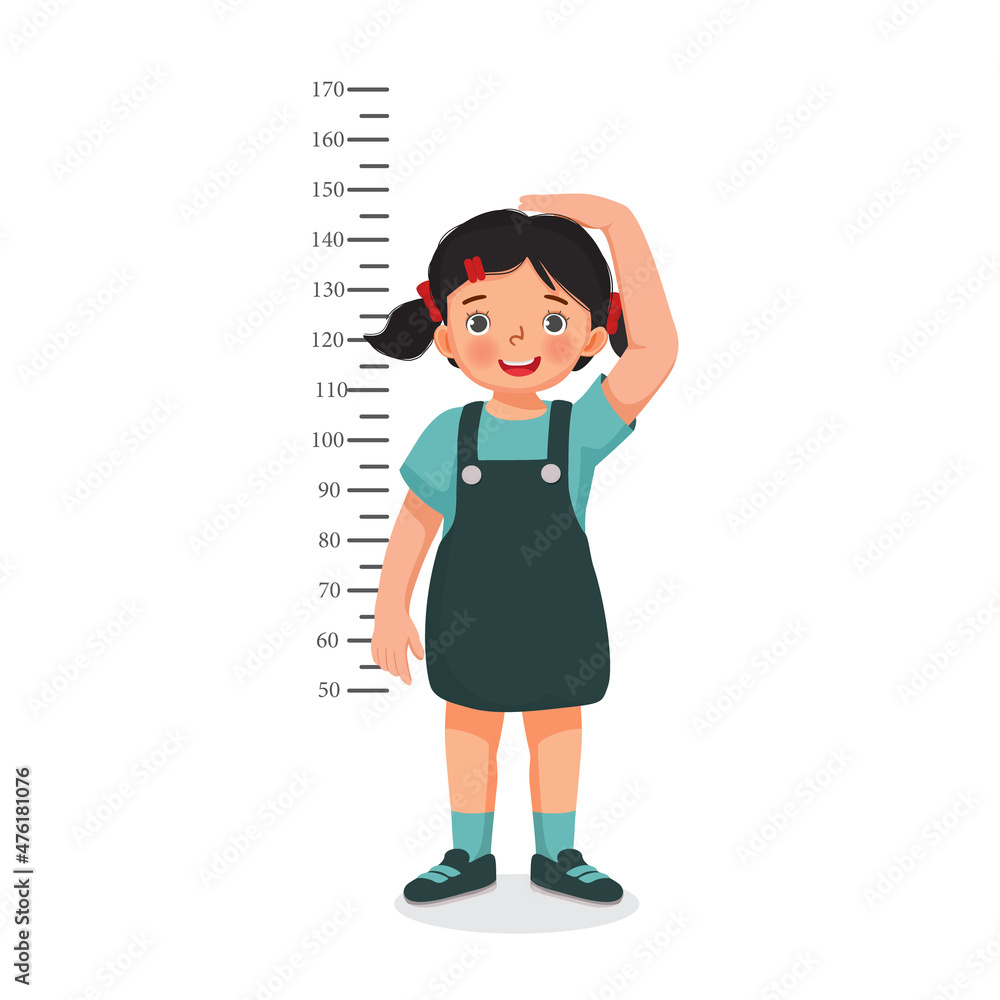 Cute Little girl measuring height of her growth on the background of wall Cute Little girl measuring height of her growth on the background of wall