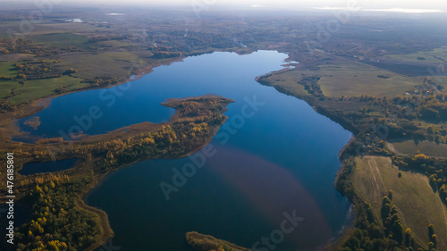 Top view of fall forest and lake. Autumn sunny evening over a forest lake.