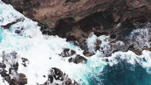 Aerial view of waves break on rocks of Faroe islands cliffs in a blue ocean.Drone Aerial Footage of green nature and the ocean. photo