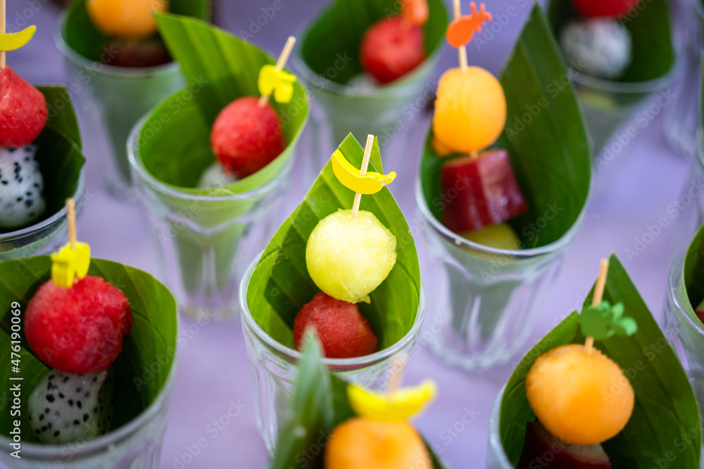 Set of various ripe fruits such as melon, cantaloupe or watermelon is glass cup, placed on purple tablecloth. Dessert food object photo, close-up and selective focus. Set of various ripe fruits such as melon, cantaloupe or watermelon is glass cup, placed on purple tablecloth. Dessert food object photo, close-up and selective focus.