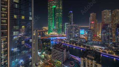 Panorama showing Dubai Marina skyscrapers and JBR district with luxury buildings and resorts aerial night timelapse