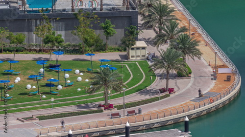 Old wooden ship passing near waterfront promenade aerial timelapse.