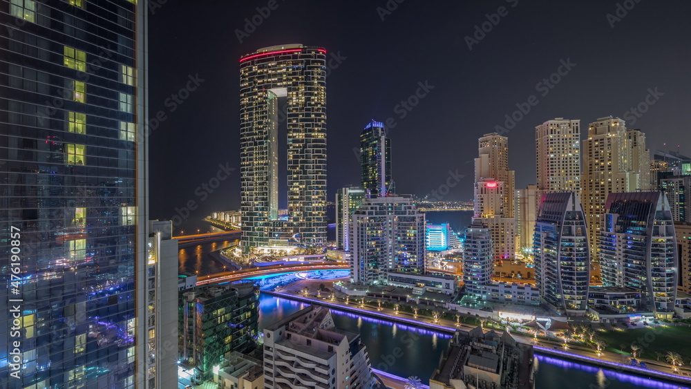 Dubai Marina skyscrapers and JBR district with luxury buildings and resorts aerial timelapse during all night with lights turning off. Dubai Marina skyscrapers and JBR district with luxury buildings and resorts aerial timelapse during all night with lights turning off.