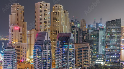 Dubai Marina skyscrapers and JBR district with luxury buildings and resorts aerial timelapse during all night with lights turning off © neiezhmakov
