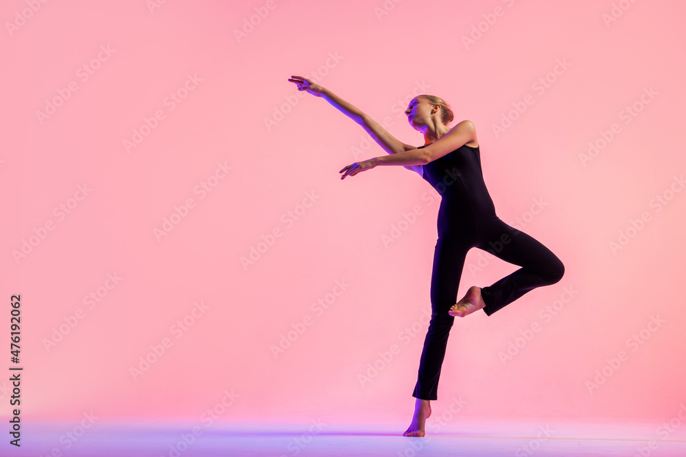 Young teenager dancer dancing on a red studio background. Ballet, dance, art, modernity, choreography concept Young teenager dancer dancing on a red studio background. Ballet, dance, art, modernity, choreography concept