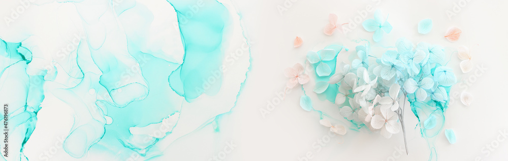 Creative image of pastel blue and pink Hydrangea flowers on artistic ink background. Top view with copy space Creative image of pastel blue and pink Hydrangea flowers on artistic ink background. Top view with copy space