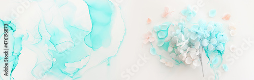 Creative image of pastel blue and pink Hydrangea flowers on artistic ink background. Top view with copy space