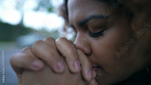 Spiritual black woman closing eyes in contemplation, Brazilian girl opening eye to sky with HOPE