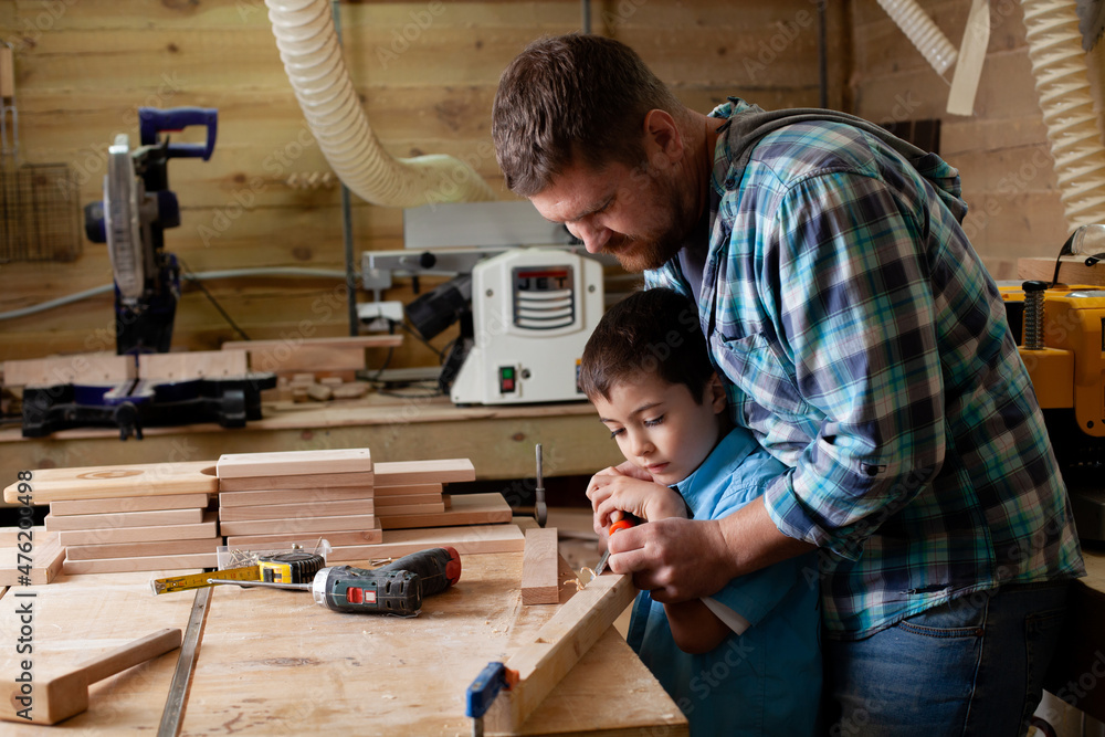 Fotografie Father carpenter and son boy work in the workshop